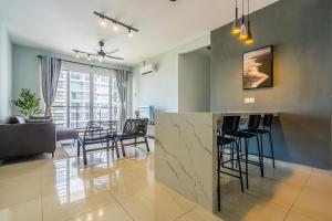 a kitchen and living room with a bar and chairs at Cozy 3-bedroom condo with pool 6 pax - Semarak in Kuala Lumpur