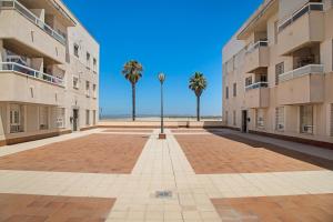 dziedziniec z palmami i światłem ulicznym w obiekcie Apartamento Colibri w mieście Puerto Real