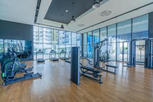 a gym with cardio equipment in a building with windows at Cozy 3-bedroom condo with pool 6 pax - Semarak in Kuala Lumpur