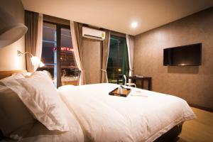 um quarto de hotel com uma cama e uma televisão em C U Inn Bangkok - SHA Plus em Bangkok