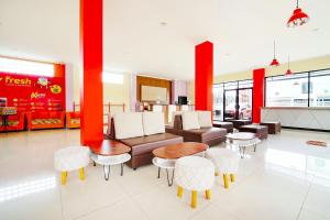 a living room with a couch and tables and chairs at Collection O 91345 Myroom Hotel in Yogyakarta