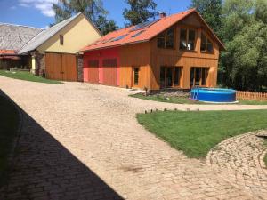 a house with a red roof and a brick driveway at Kyprův mlýn in Knínice