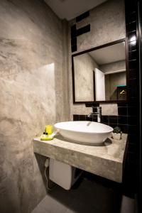 ein Badezimmer mit einem großen weißen Waschbecken und einem Spiegel in der Unterkunft C U Inn Bangkok - SHA Plus in Bangkok