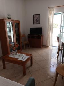 sala de estar con mesa de centro y TV en Casa da Zi, en Vila Nova de Milfontes