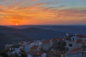 - une vue sur une ville avec le coucher du soleil en arrière-plan dans l'établissement Casas Da Lapa, Nature & Spa Hotel, à Seia