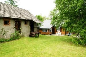 a house with a yard next to a building at Chatka na Roztoczu in Bondyrz