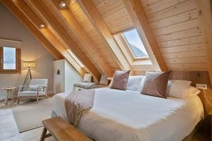 a bedroom with a large white bed in a attic at Luderna - Duplex Corilha in Gessa