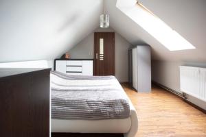 een slaapkamer op zolder met een bed en een dakraam bij Apartament Tyniecki in Darłowo