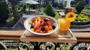 a bowl of fruit on a wooden table with a drink at Utopía Hotel Boutique in Mexico City