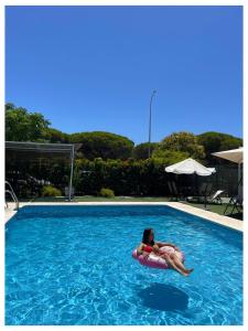 una mujer montando en una balsa en una piscina en Hotel Albaida Nature, en Mazagón