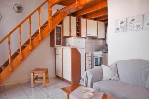 a living room with a couch and a kitchen at STUDIOS ATHENA in Megalochori