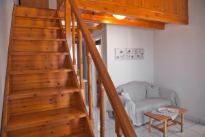 a staircase in a living room with a chair and a table at STUDIOS ATHENA in Megalochori