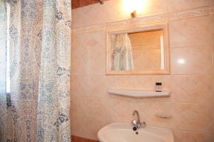 a bathroom with a sink and a mirror and a shower at STUDIOS ATHENA in Megalochori