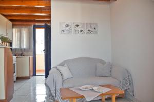 a living room with a couch and a table at STUDIOS ATHENA in Megalochori