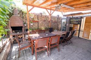 a patio with a table and chairs and an outdoor oven at Casa Maria in Constanţa +33 photos