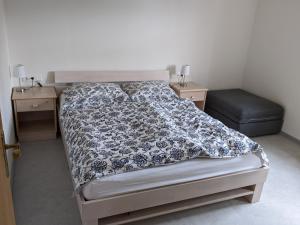 Schlafzimmer mit einem Bett mit einer schwarzen und weißen Bettdecke in der Unterkunft Ferienwohnung Grenzenblick in Bayerisch Eisenstein