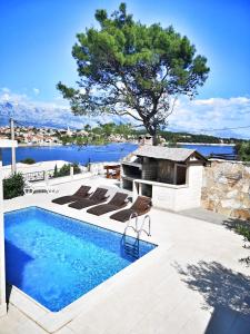 basen z leżakami i widokiem na wodę w obiekcie Villa Sky with stunning view w mieście Selca