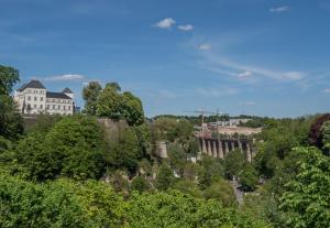 a building on top of a hill with trees at LUXURY PENTHOUSE APARTMENT WITH 3 Balconies -2 BEDROOMS & PETRUS VIEW in Luxembourg