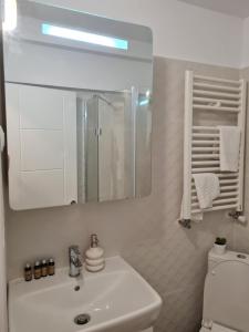 a white bathroom with a sink and a mirror at Cozy Residence in Bucharest