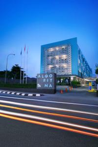 un edificio con un letrero al lado de una carretera en Algoritma Hotel, en Palembang