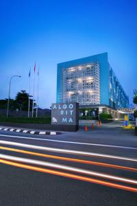 a building with a sign on the side of a road at Algoritma Hotel in Palembang