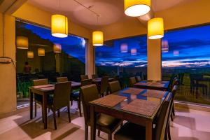 un restaurante con mesas y sillas y una gran ventana en Warmth Hill Crest en Kodaikānāl