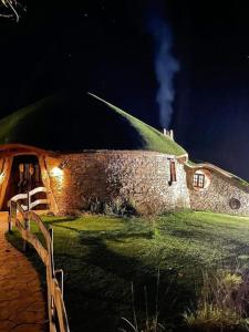 un edificio de piedra con techo verde por la noche en Fogar de Breogán, en Pontevedra