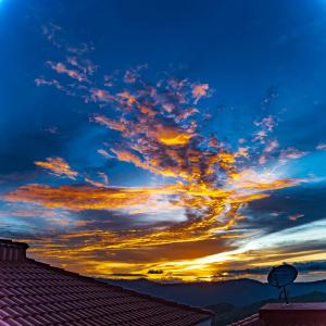 een zonsondergang vanaf het dak van een huis bij Warmth Hill Crest in Kodaikānāl