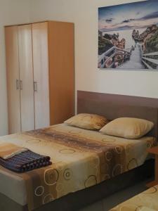 a bedroom with a bed and a painting on the wall at Apartments Petricevic in Sutomore