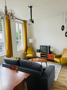 sala de estar con sofá y TV en Le Vintage 70's, 4 à 6 pers, centre-ville en Boulogne-sur-Mer
