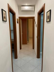 korytarz z drzwiami i podłogą wyłożoną kafelkami w obiekcie Casa Milano - Sottomarina w mieście Sottomarina