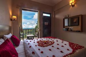 Un dormitorio con una cama con flores rojas. en Warmth Hill Crest en Kodaikānāl
