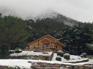 una cabaña de madera en la nieve en una montaña en El Refugi de la Torre Espinalbet, en Castellar del Riu