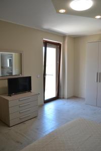 ein leeres Wohnzimmer mit einem TV und einer Tür in der Unterkunft Agriturismo I 3 Fratelli in Sala Consilina