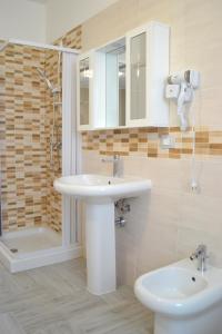 ein Badezimmer mit einem Waschbecken, einem WC und einem Spiegel in der Unterkunft Agriturismo I 3 Fratelli in Sala Consilina