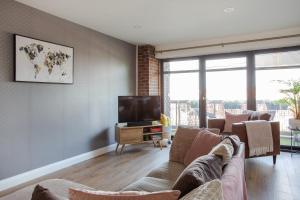 a living room with a couch and a tv at New Lisburn Road Apartment - Free Parking in Belfast