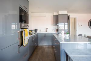 a kitchen with blue cabinets and a counter top at New Lisburn Road Apartment - Free Parking in Belfast