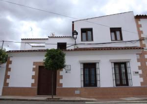 a white building with a tree in front of it at Casa Rural El Corralillo del Abuelo 