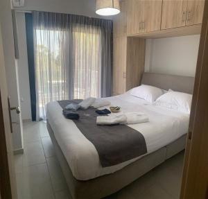 a bedroom with a large bed with towels on it at Melivia Luxury Suite in Nikiana