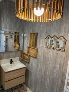 a bathroom with a sink and a mirror at La Boussole centre station proche mer in Agon Coutainville
