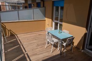 un tavolo blu e sedie sul balcone di DOMUS PINAE Casa vacanze a Pescara
