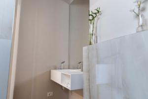 a white bathroom with a sink and a mirror at DOMUS PINAE Casa vacanze in Pescara +15 photos