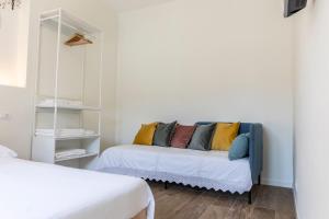 Habitación con sofá y almohadas coloridas. en DOMUS PINAE Casa vacanze en Pescara