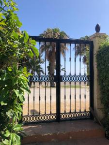an iron gate with a view of the beach at POLL ALL YEAR, PISCINA TODO EL AÑo in Torre de Benagalbón