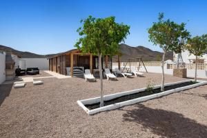 a playground with chairs and trees in a yard at La Cabañita de Javi in Tuineje