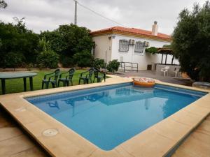 una piscina en un patio trasero con mesa y sillas en Chalet con piscina en Níjar, en Níjar