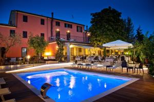 a swimming pool in front of a building at night at Hotel La Palomba in Mondavio