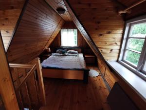 a bedroom in a log cabin with a bed in the attic at Dom Letniskowy, Siła in Sila