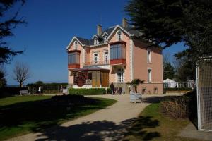 a large pink house with a large roof at La Boussole centre station proche mer in Agon Coutainville