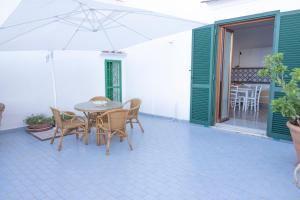 a patio with a table and chairs and an umbrella at Emerald's Resort - Filomena in Conca dei Marini